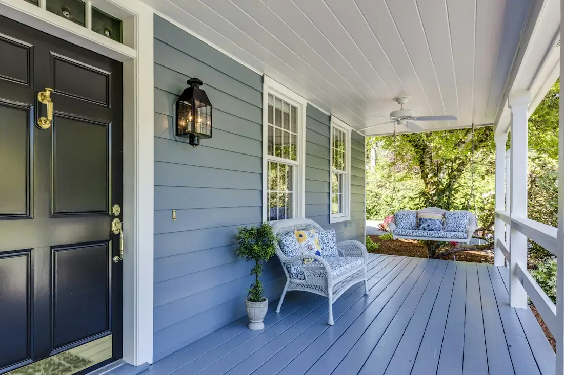 A welcoming front porch with a white bench and potted plants